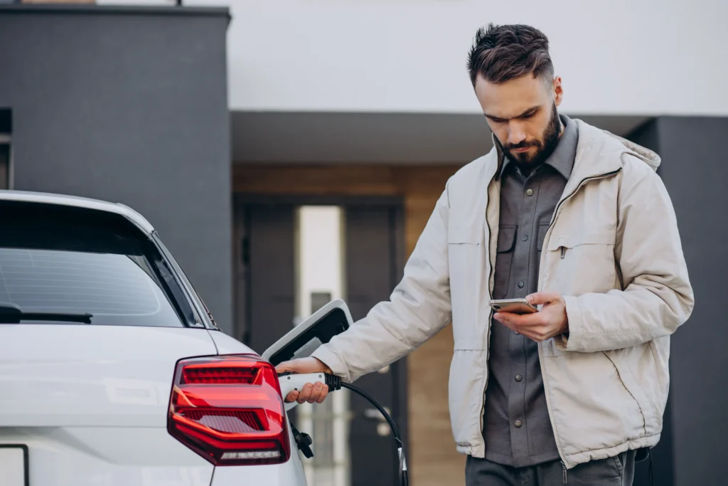 Homme rechargeant son véhicule électrique